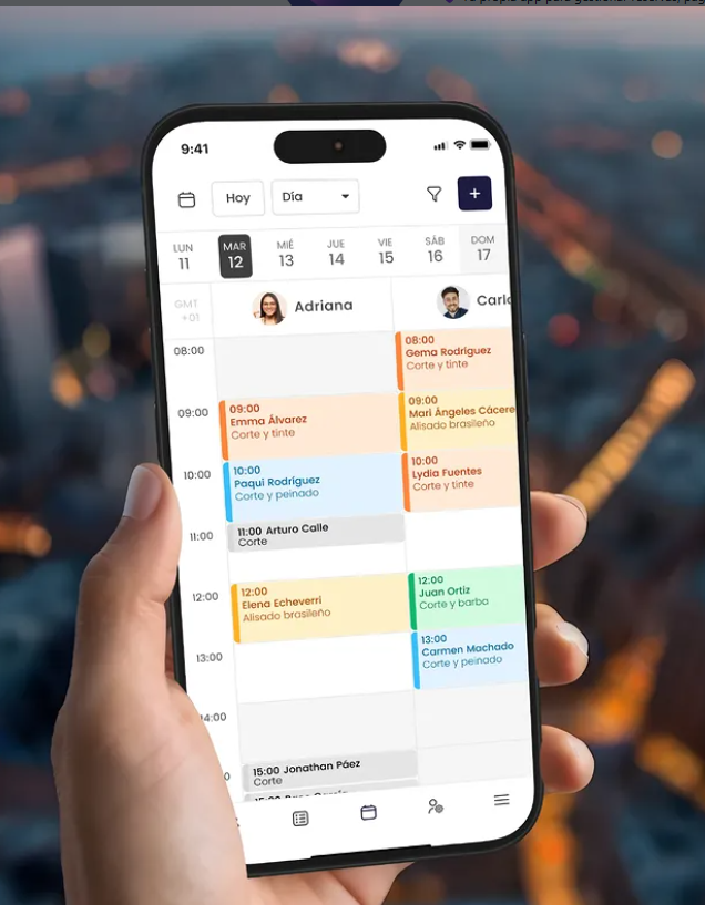 Pantalla de móvil con agenda de citas de peluquería, mostrando horarios y servicios, sostenido por una mano.