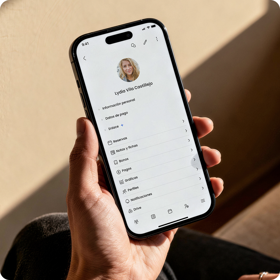 Persona sosteniendo un móvil que muestra la pantalla de un perfil personal con opciones de configuración.